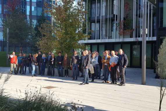 Teilnehmer:innen an einer Exkursion zum "Kraftwerk Kriau, Viertel vor 2" vor einem neuen Gebäude