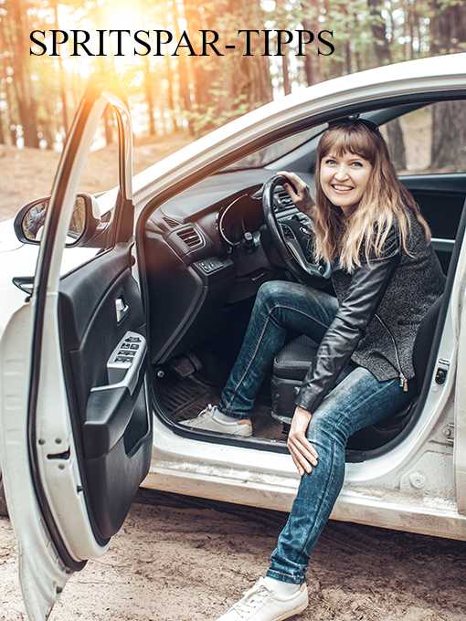 Eine Frau sitz in einem offenem Auto und lacht in die Kamera