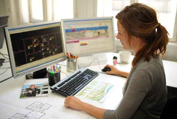 Frau sitzt am Schreibtisch, vor einem Bildschirm, beim e-learning