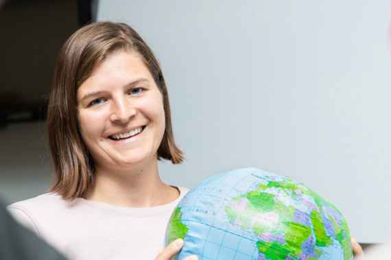 Umweltpsychologin Anna Pribil mit einer Weltkugel in der Hand