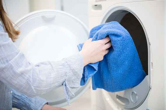 Eine Frau räumt eine Waschmaschine ein