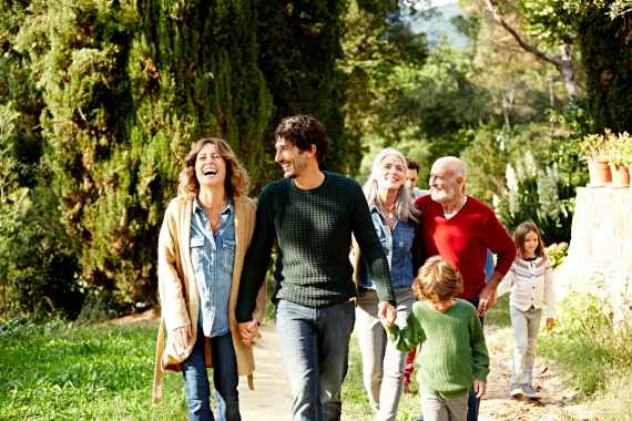Glückliche Familie geht zu Fuß im Grünen
