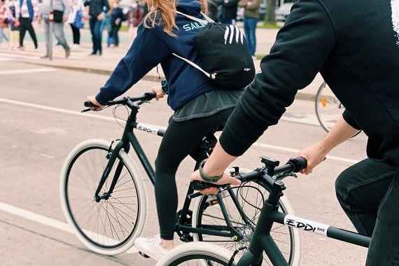 Zwei Personen fahren auf Fahrräder in der Stadt.