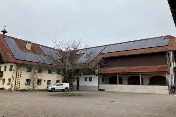 Gelber Gutshof mit Solarpanelen am Dach