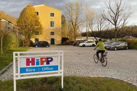 Eine Person fährt mit dem Fahrrad auf das Firmengelände von HIPP.