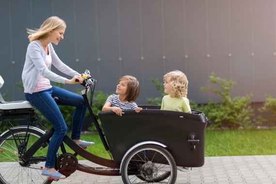 Mutter und Kinder fahren zusammen mit dem Transportrad