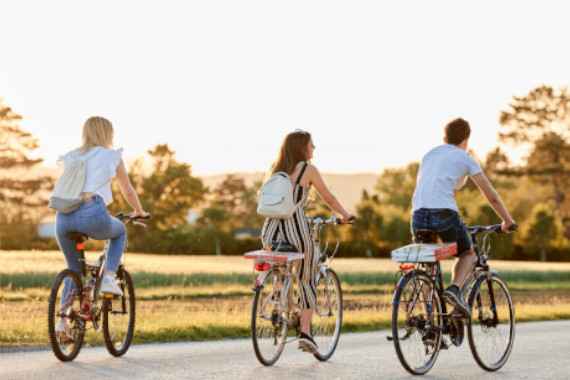 Drei Radfahrer:innen fahren nebeneinander  