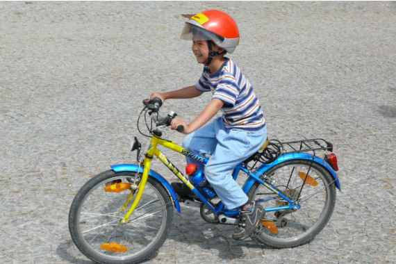 Kind mit Helm auf Fahrrad