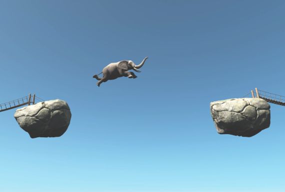 Elefant springt über eine Schlucht zwischen 2 Felsbrocken