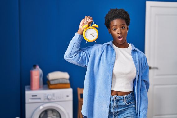 African american woman waiting for laundry scared and amazed with open mouth for surprise, disbelief face