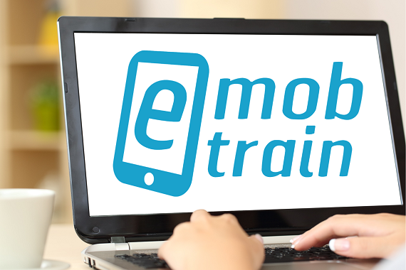Person sitzt vor einem Laptop, auf dem Bildschirm ist das E-Mob-Train-Logo zu sehen.