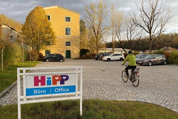Eine Person fährt mit dem Fahrrad auf das Firmengelände von HIPP.