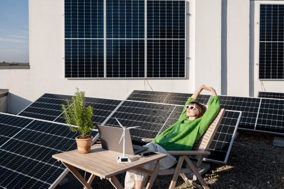 Woman works on a rooftop with a solar power plant