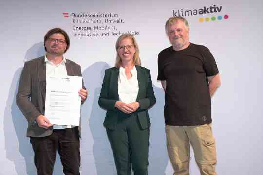 Im Bild: Klimaschutzministerin Leonore Gewessler, Karlheinz Abraham (Drau Wohnbau gemeinn. GmbH), Gerald Werkl (ge.werk Architektur)