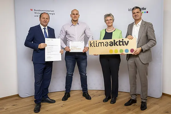mehrere Personen mit Urkunde in der Hand schauen in die Kamera