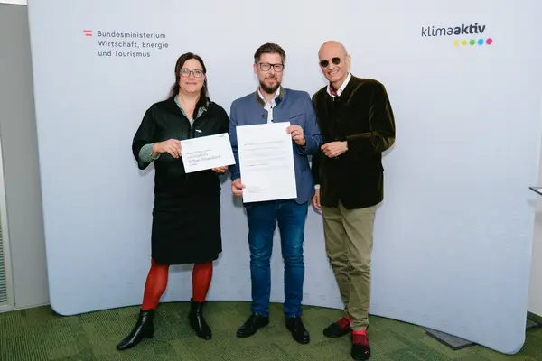 Personen mit Urkunden schauen in die Kamera