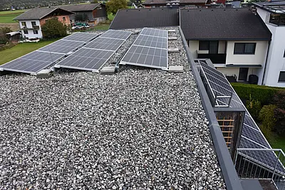 3 PV-Paneele auf einem Schotterdach.