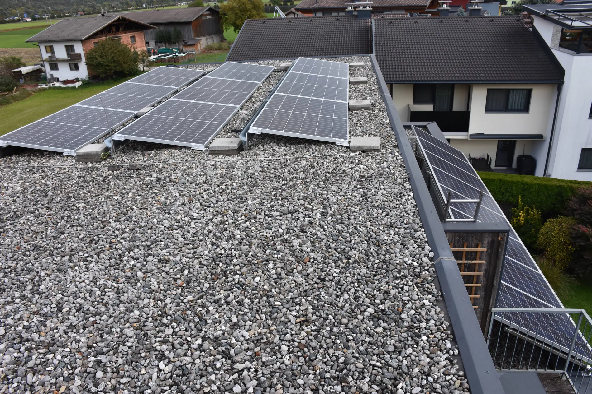 3 PV-Paneele auf einem Schotterdach.