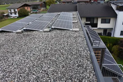 3 PV-Paneele auf einem Schotterdach.