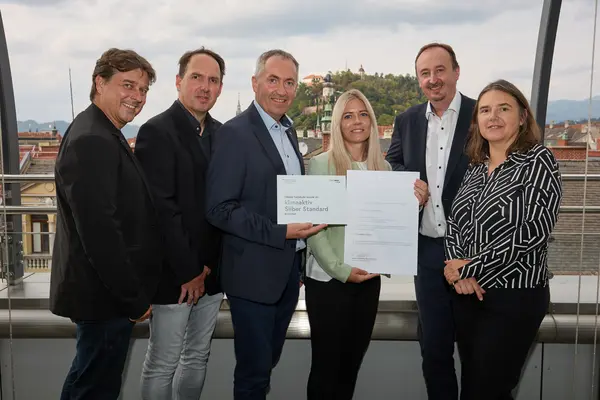 6 Personen mit Urkunden schauen in die Kamera