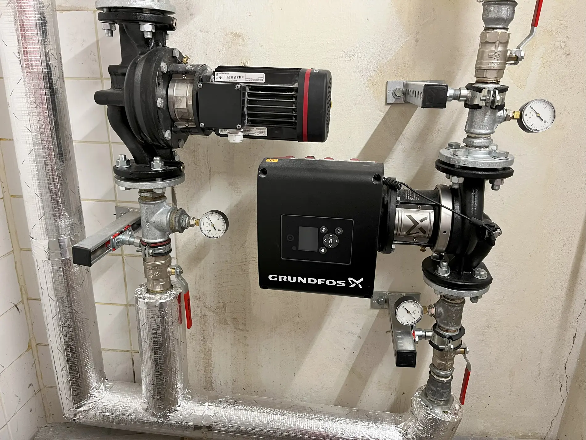 Rohrsystem mit zwei Transportpumpen und Druckanzeigen für erhitztes Wasser von Kompressoren.