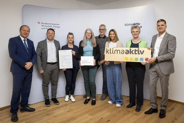 mehrere Personen mit Urkunde in der Hand schauen in die Kamera