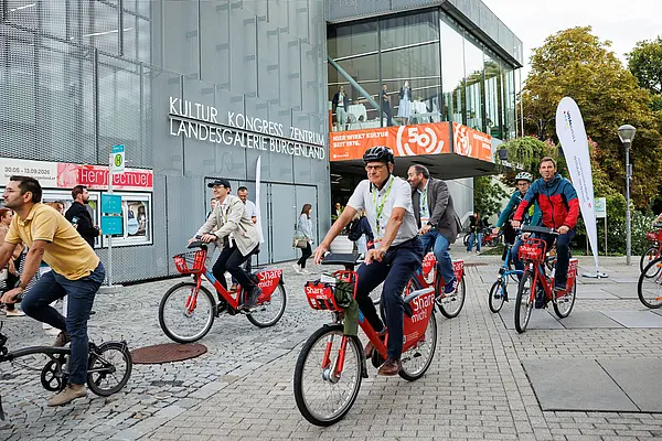 Viele Radfahrende vor dem Kongressgebäude Eisenstadt; fahrend