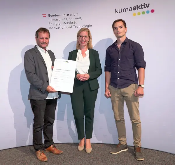 Im Bild: Klimaschutzministerin Leonore Gewessler, Tobias Schmerlaib und Wolfram Stöby (Fortschritt Gemeinnützige Bau-, Wohnungs- und Siedlungsgenossenschaft für Kärnten)