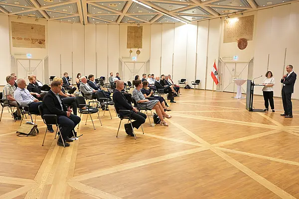 Die Kompetenzpartner:innen sitzen im Saal verteilt