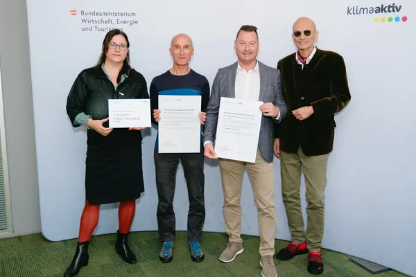 Personen mit Urkunden schauen in die Kamera