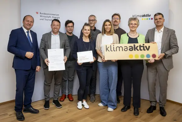 mehrere Personen mit Urkunde in der Hand schauen in die Kamera