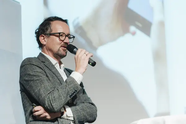 Mann am Podium spricht mit Mikro