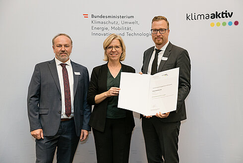 Auszeichnung von klimaaktiv Vorzeigebetrieb König GmbH & Co KG König durch Klimaschutzministerin Leonore Gewessler (BMK). Im Bild: Christoph Hackl (Geschäftsführer / CCO) (rechts), Manfred Faßwald (Leitung Haus- und Betriebstechnik) (links) mit Klimaschutzministerin Leonore Gewessler (BMK) (mitte)