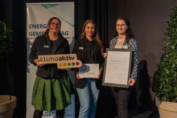 Personen mit Urkunden schauen in die Kamera