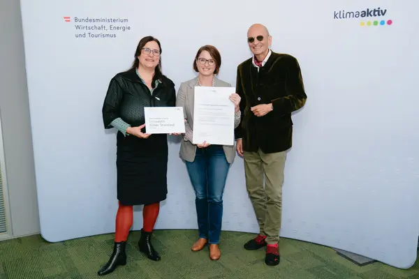 Personen mit Urkunden schauen in die Kamera