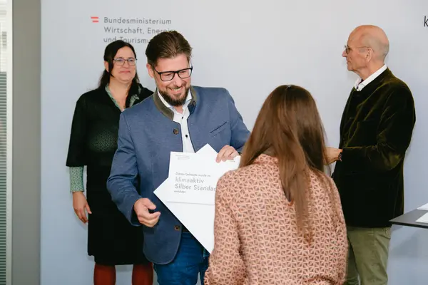 Personen mit Urkunden schauen in die Kamera