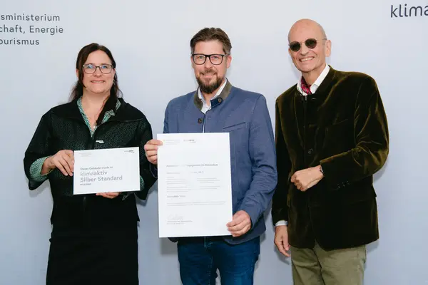 Personen mit Urkunden schauen in die Kamera