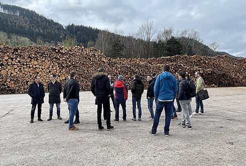Teilnehmer:innen der Exkursion vor dem Rundholzlagerplatz