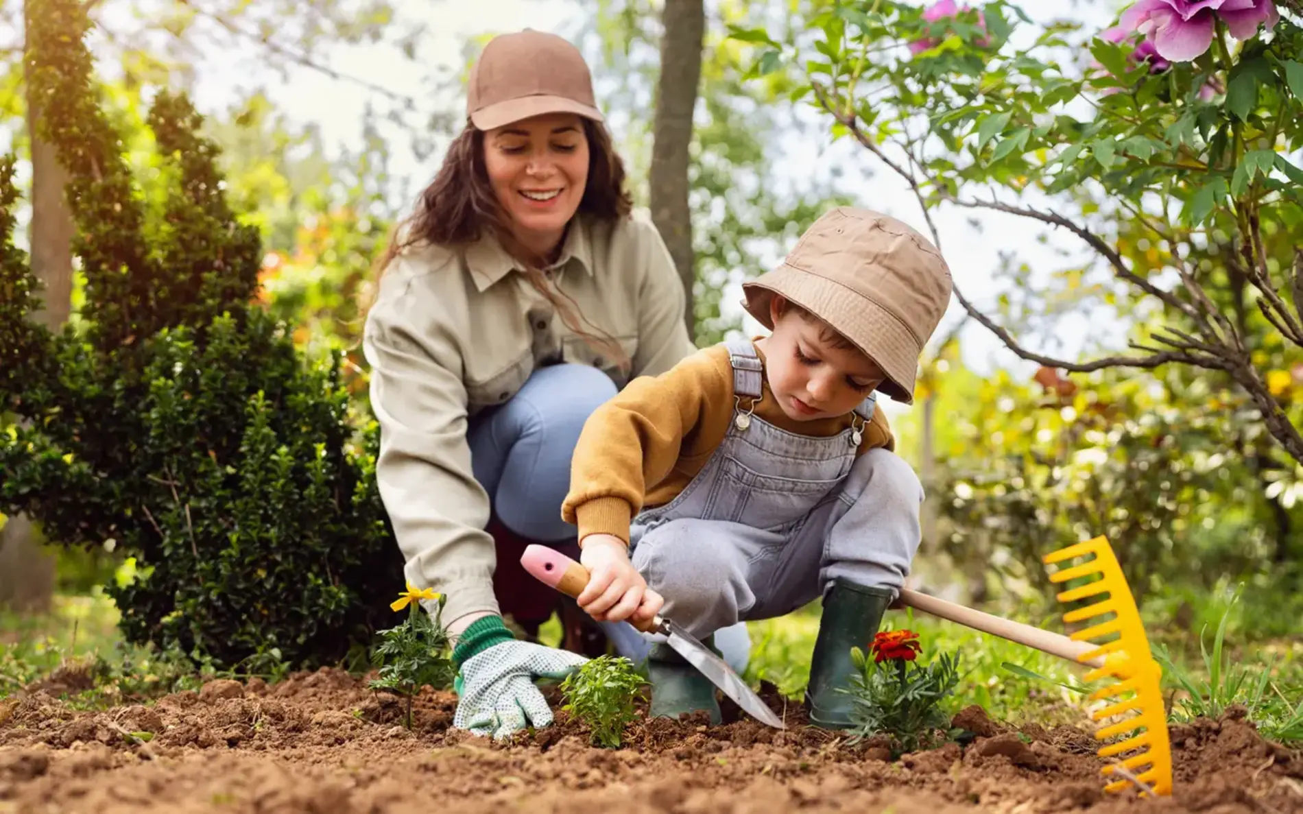 Mutter und Kleinkind graben zusammen den Garten um