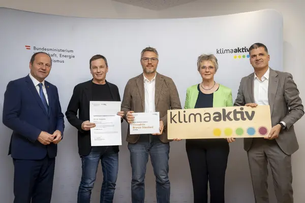 mehrere Personen mit Urkunde in der Hand schauen in die Kamera