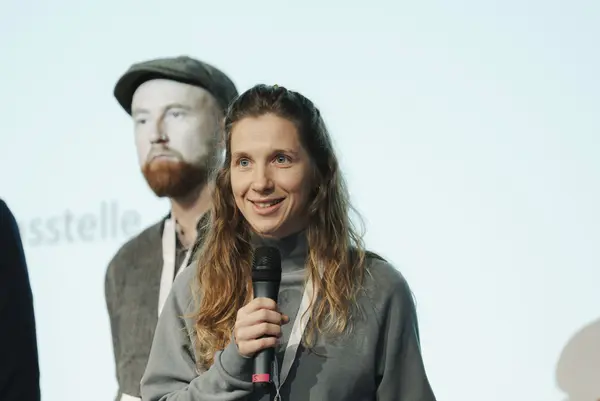 Frau mit Mikro am Podium