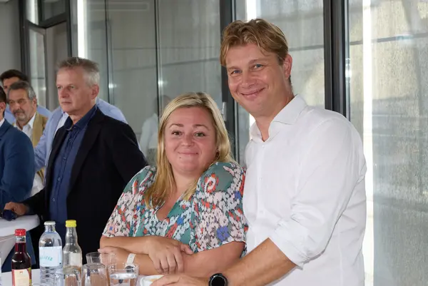 2 Personen auf einer Feier lächeln in die Kamera