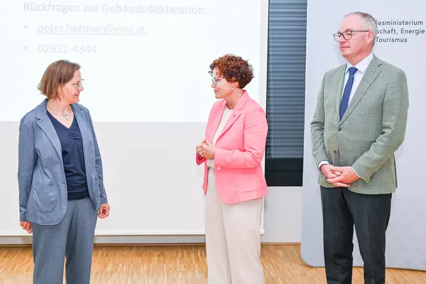 3 Personen auf einer Bühne vor einer Logowand klimaaktiv und BMWET