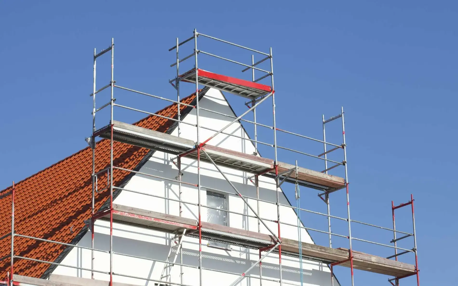Der obere Teil eines Hauses. Rundherum ist ein Baugerüst aufgestellt.