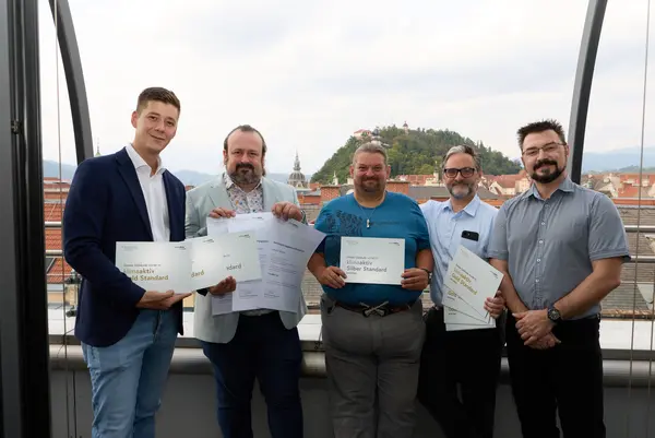 5 Personen mit Urkunde schauen in die Kamera