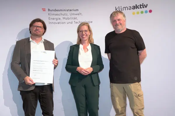Im Bild: Klimaschutzministerin Leonore Gewessler, Karlheinz Abraham (Drau Wohnbau gemeinn. GmbH), Gerald Werkl (ge.werk Architektur)