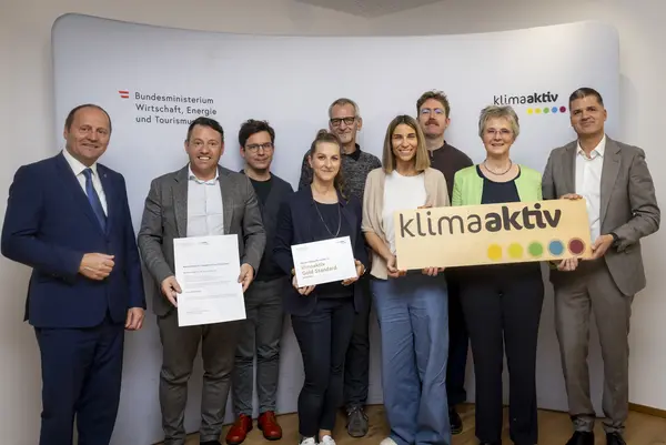 mehrere Personen mit Urkunde in der Hand schauen in die Kamera