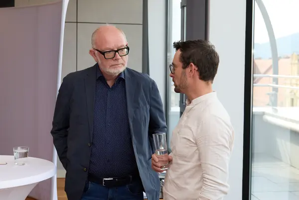 Besucher:innen einer Veranstaltung unterhalten sich