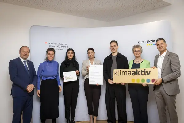 mehrere Personen mit Urkunde in der Hand schauen in die Kamera