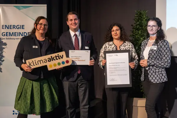 Personen mit Urkunden schauen in die Kamera